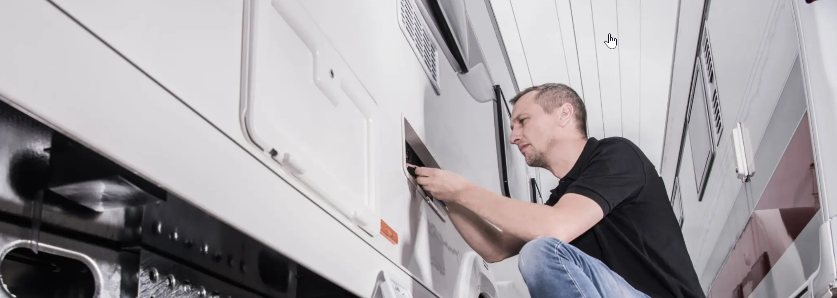 Petoskey RV USA technician performing exterior compartment service